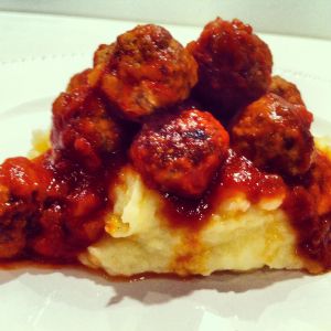 Gorgeous meatballs sitting on a bed of creamy mash